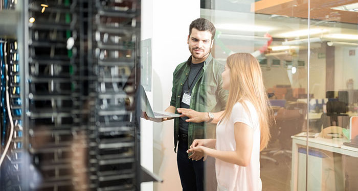 two colleagues chatting in a computer server room