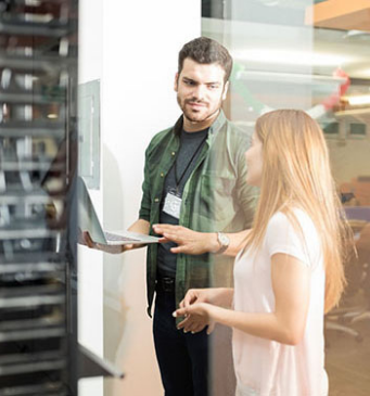 two colleagues chatting in a computer server room